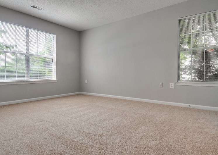 Empty bedroom with carpet and two windows